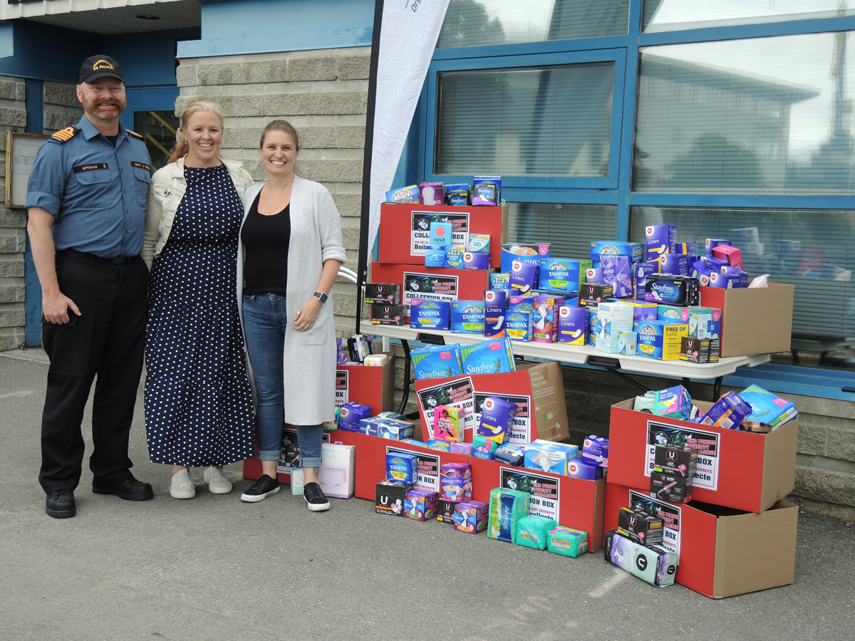 (Left): Captain (Navy) Peter Sproule, Maritime Forces Pacific Chief of Staff, and Captain Patricia Laing and Vanessa Nicholson, Defence Women’s Advisory Organizations Co-Chairs, display some of the products donated during this year’s Period Poverty Campaign.  Photo: Peter Mallett/Lookout Newspaper