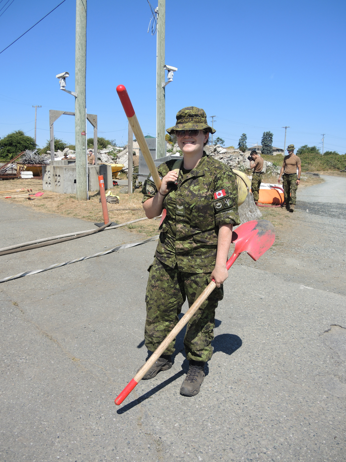 Army Reservist Corporal Kathleen Parker of the British Columbia Regiment (Duke of Connaught's Own) carries shovels used for wildfire fighting during OP Lentus Training, July 21 at CFB Esquimalt's Urban Search and Rescue Training Centre. Members of the 39 Canadian Brigade Group will deploy to British Columbia's central interior this month to fight wildfires. Photos: Peter Mallett/Lookout Newspaper