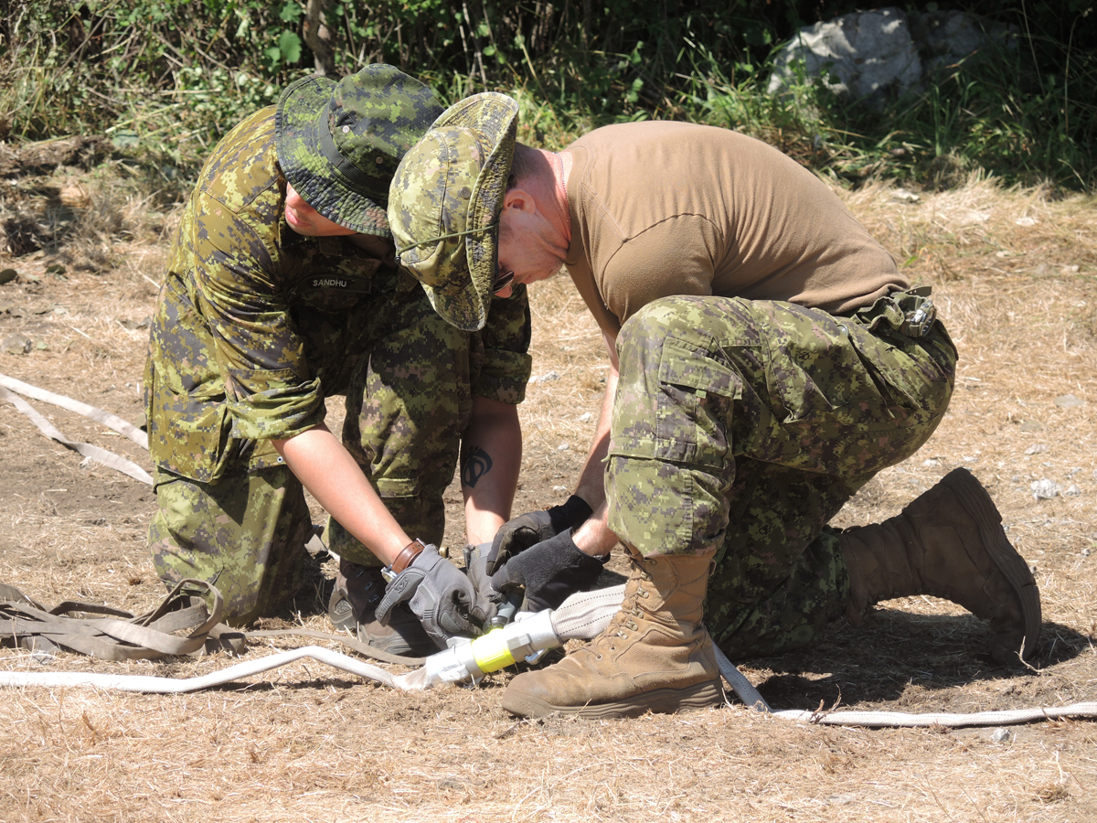 Les réservistes du 39e groupe-brigade canadien installent des lignes de distribution et des tuyaux.
