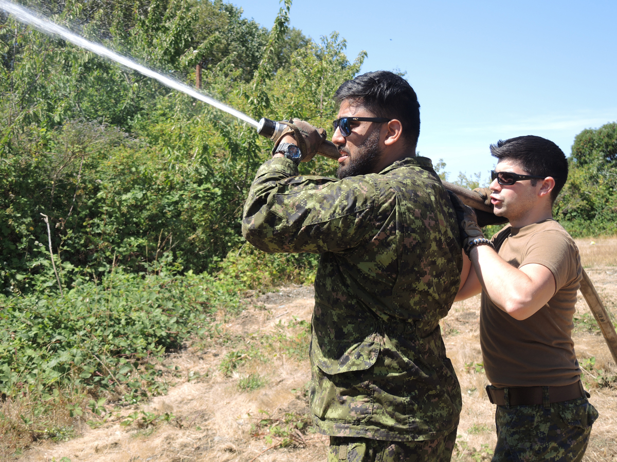 (Left) Army Reservist Corporal Harmanpreet Bangar of the British Columbia Regiment (Duke of Connaught‚'s Own) and Corporal Christopher Krastel of the 39 Brigade Group test out a fire hose and water distribution system during OP Lentus Training.