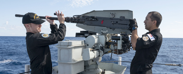 (Left to right) Sailor 3rd Class Kelley (S3) and Sailor 2nd Class (S2) Yaretz of His Majesty's Canadian Ship (HMCS) Vancouver conduct regular maintenance on the .50 calibre heavy machine gun during Exercise ANNUALEX in the Philippine Sea on 14 November 2023. Photo credit: Corporal Alisa Strelley, Canadian Armed Forces Photo.