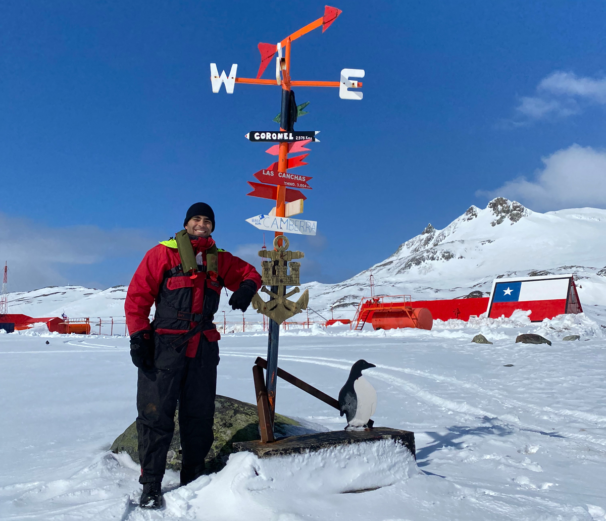 A/SLt Kayvan Aflaki stands with a landmark signpost at Captain Arturo Prat Base, a Chilean Antarctic research station located on Greenwich Island, after completing a replenishment with the crew members of Chilean offshore patrol vessel Marinero Fuentealba. Photo: ST Felipe Olea.
