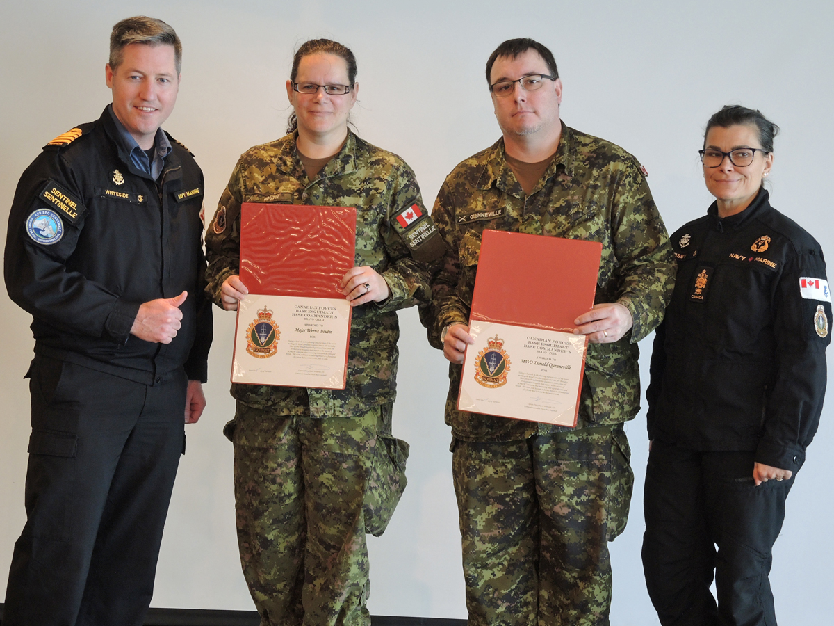 (À gauche) Le capitaine de vaisseau Kevin Whiteside, commandant de la base, et (à droite) le premier maître de 1re classe Susan Frisby, chef de la base, remettent aux logisticiens Major Weena Boutin, officier du génie mécanique électrique et de transport, et Adjudant-maître Donald Quenneville, officier de contrôle des systèmes par intérim de la logistique de la base, un certificat de reconnaissance pour l’organisation de la fête du 56e anniversaire de la base de cette année.
