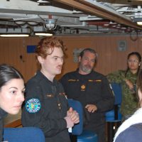 Sailor Second Class Zachary Thompson (centre) talking to Naval Reserves recruiters.