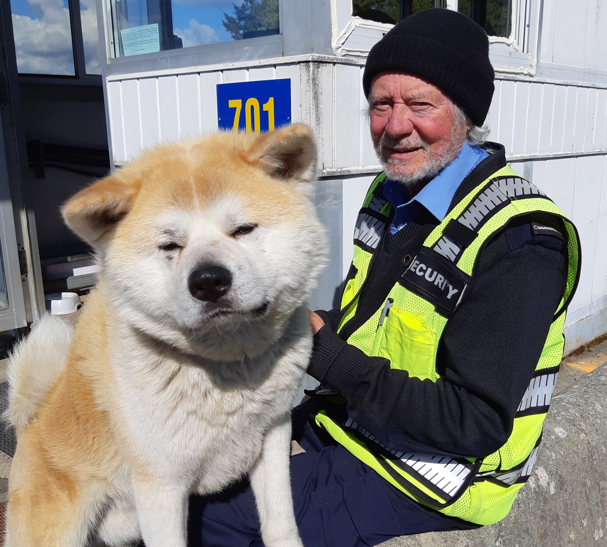 Les visages amicaux du commissionnaire Bob Cosman et de son nouveau chien Teddy sont prêts à accueillir les visiteurs à la barrière de sécurité Y-Jetty de la BFC Esquimalt. Photo : Peter Mallett/Lookout.
