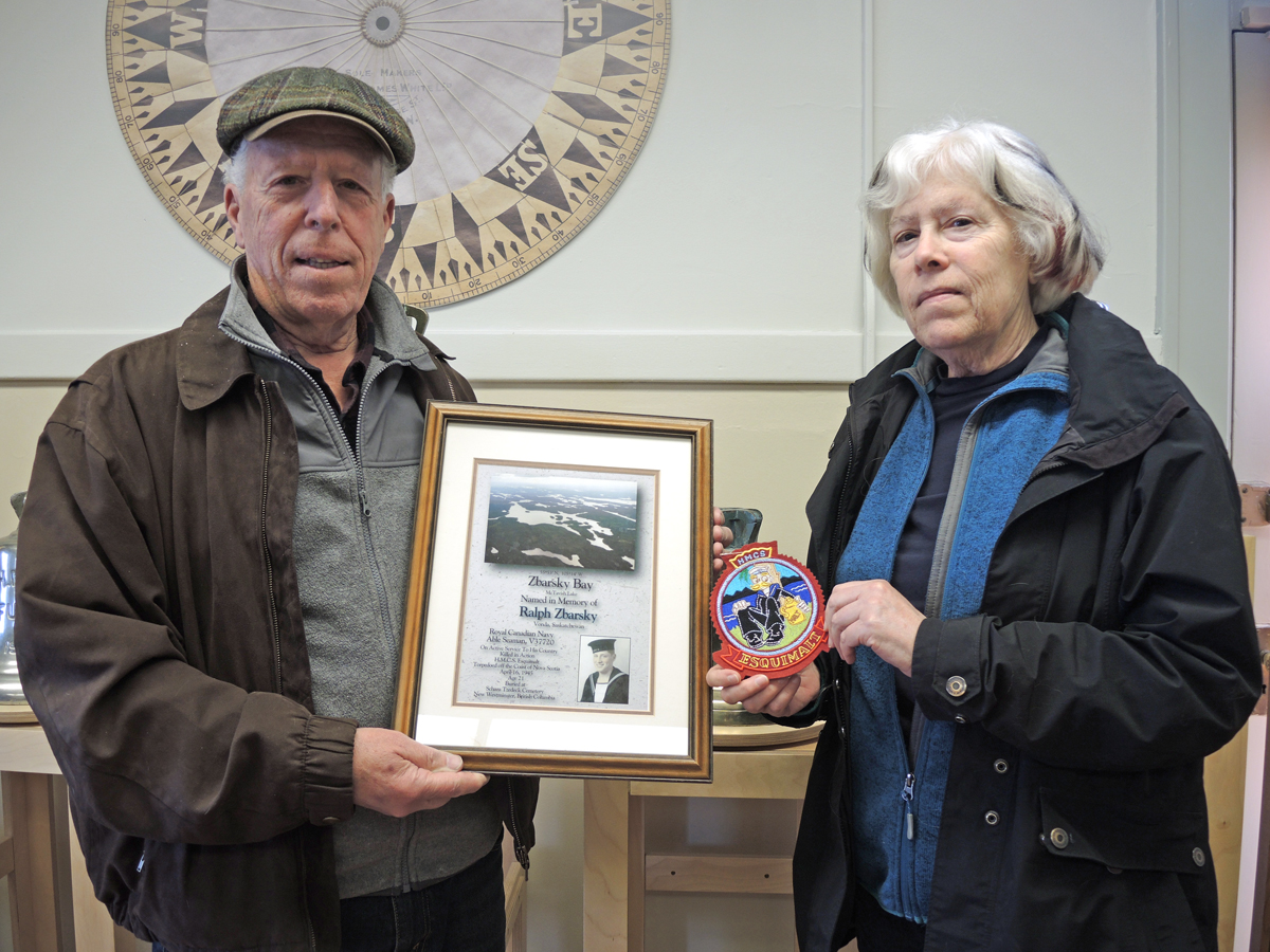 Ralph Zbarsky et sa sœur Debby montrent une plaque commémorant le baptême de la baie Zbarsky, en Saskatchewan, et un écusson de moral du NCSM Esquimalt au Musée naval et militaire de la BFC Esquimalt, le 16 avril. PhotoS : Peter Mallett/Lookout.