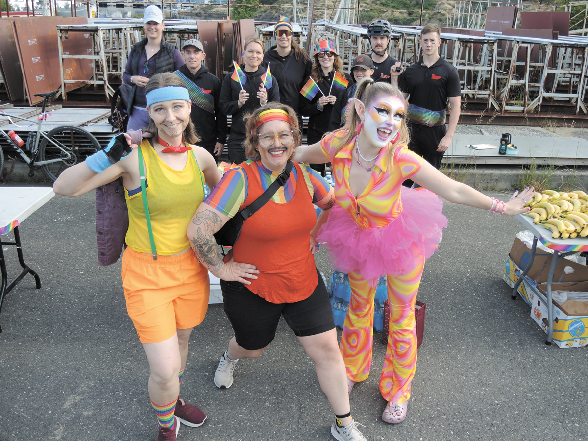 Sheena Finkbiner, Lt(N) Lindsey Bookham and Malia Copley strike a pose with PSP staff while wearing pride colours ahead of warmups. Photos: Peter Mallett/Lookout Newspaper